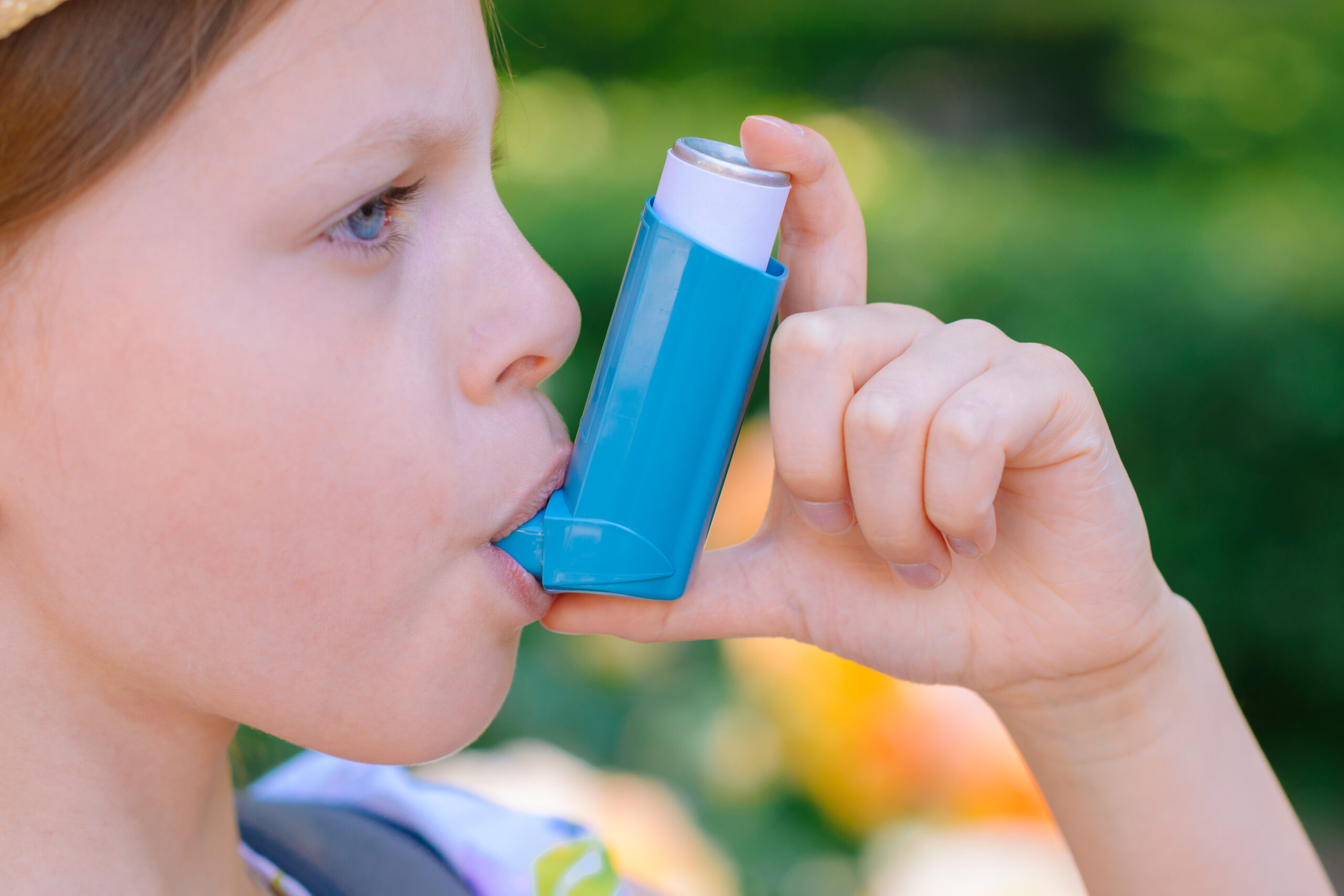 A child using a blue asthma inhaler