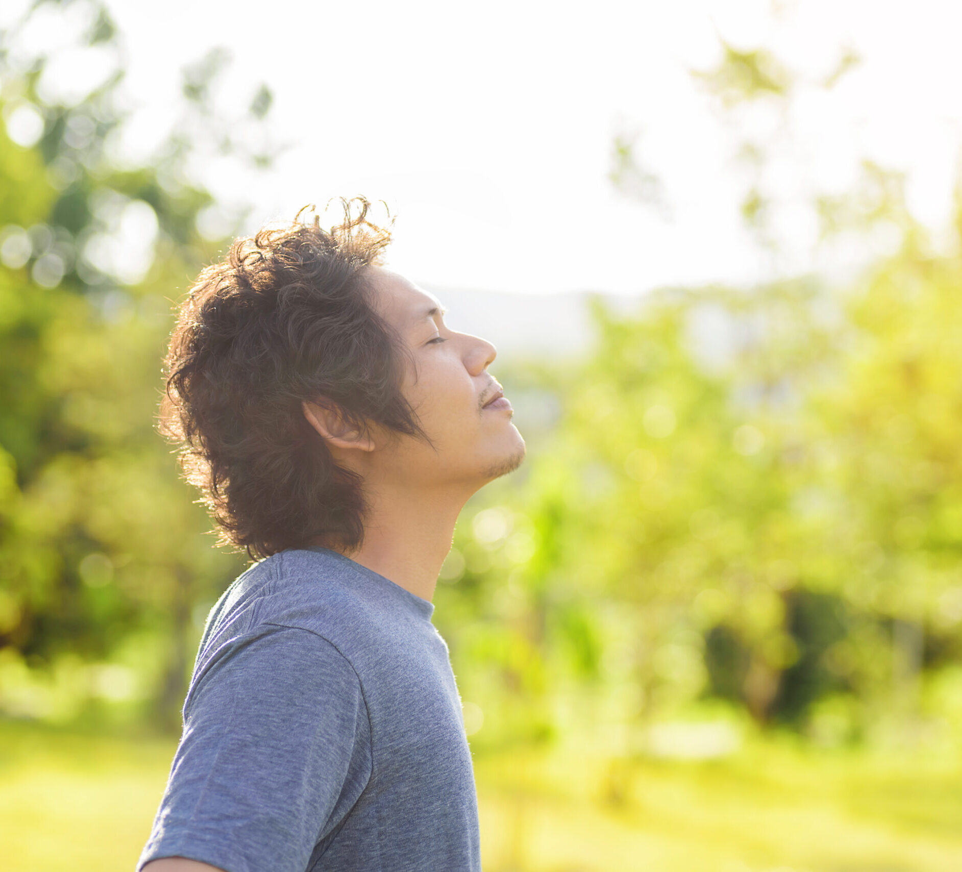 Happy Asian man breathing deeply in outdoor. Image by nungning20 on Adobe Stock.